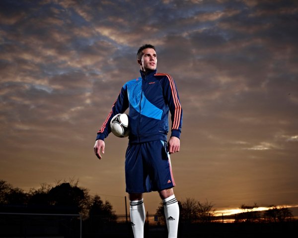Footballer Robin van Persie with the ball on the sky bac